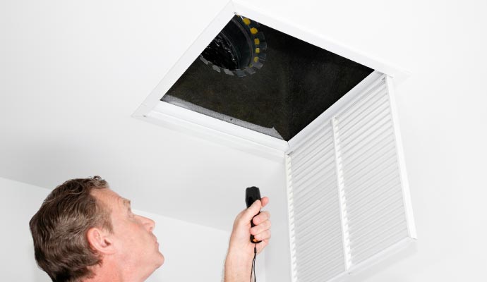 Person inspecting a duct with equipment