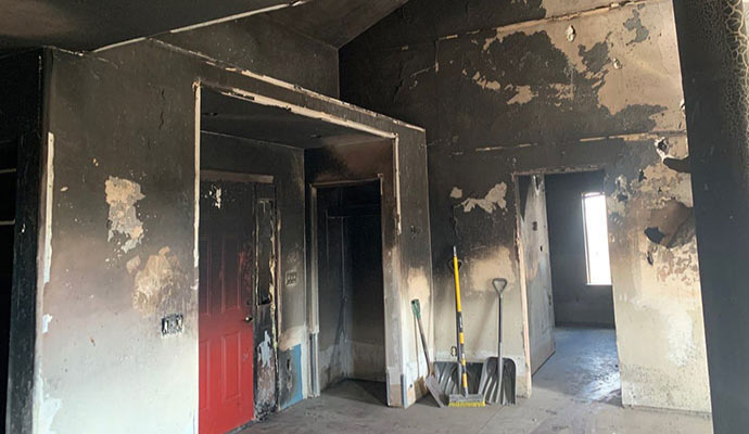A fire-damaged room with soot damaged walls and ceiling