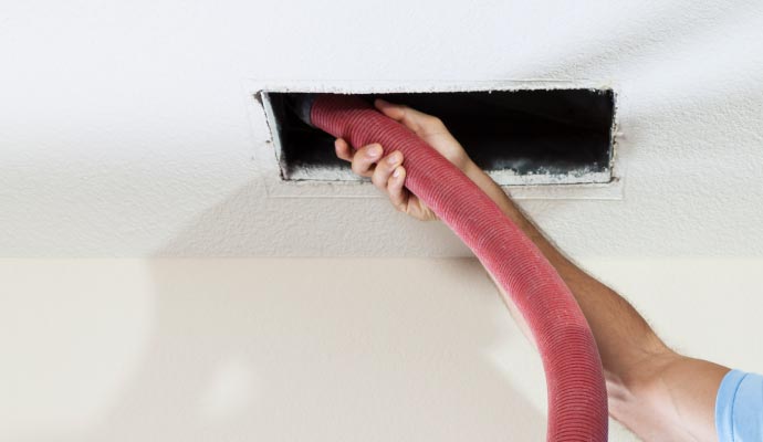 Person cleaning mold from an HVAC system