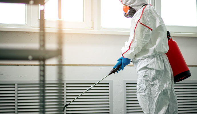 Professional worker cleaning biohazard waste