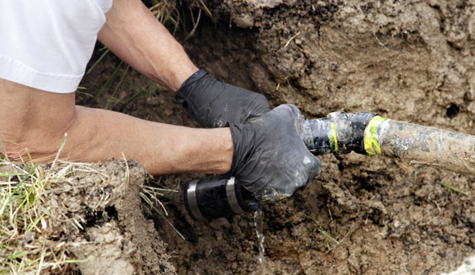 Professional worker fixing broken water pipe